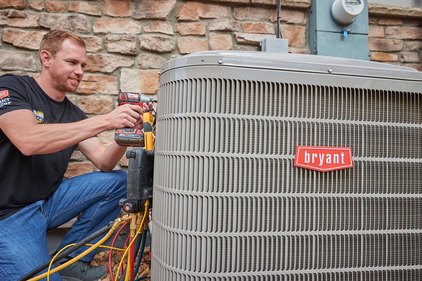 A technician working on a Bryant outdoor heat pump