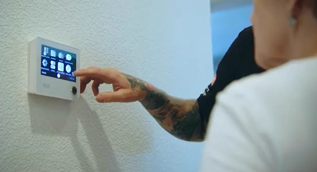 A smart WiFi thermostat on a living room wall